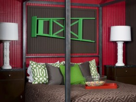 Спальня в темных оттенках с красными стенами и зеленой лестницей над кроватью