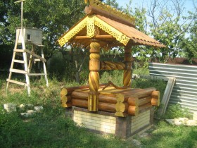 Carved wooden well with brick base