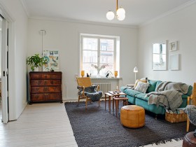 Интерьер белой гостиной с камином и серым ковром