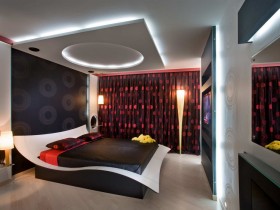 Спальня с дизайнерской кроватью и многоуровневым потолком
