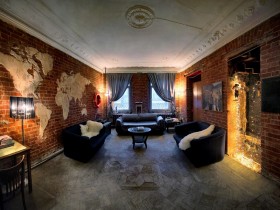 Оригинальная гостиная с кирпичными стенами и черной мебелью