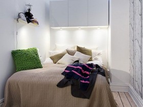 Маленька біла спальня з дерев'яною підлогою