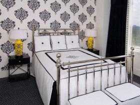 Black and white bedroom with yellow lamps