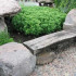 An unusual garden bench made of boulders with their hands