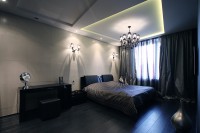 Dark bedroom with tiered ceiling and beautiful bathroom fixture