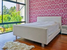 Современная спальня с розовыми обоями и большим окном
