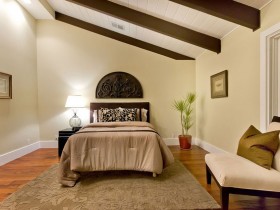 Спальня со скошенным потолком в теплых оттенках