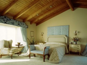 Спальня в классическом стиле с деревянным скошенным потолком