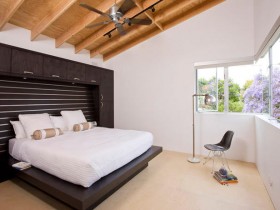 Маленькая современная спальня с деревянным скошенным потолком