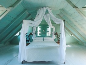 Спальня в стиле прованс с кроватью под балдахином и скошенным потолком