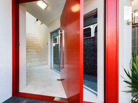 Красная входная дверь в коттедж оригинального дизайна