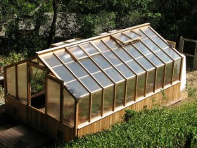 The greenhouse is made of wood and polycarbonate