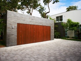 Кирпичный гараж с деревянными воротами в современном стиле