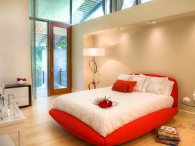 Светлая спальня с красной кроватью
