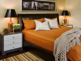 Спальня с черной кроватью и оранжевым пастельным бельем