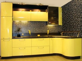 Желтая кухонная мебель на фоне черных стен