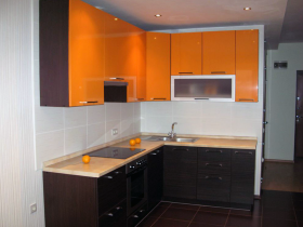 Оранжево-черная мебель в белой кухне