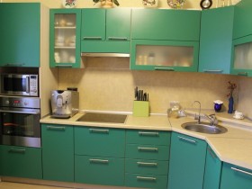 Интерьер маленькой яркой кухни с зеленой мебелью