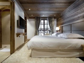Интерьер спальни в деревянной отделке с большим окном