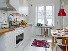 Кухня белого цвета с ярким ковриком