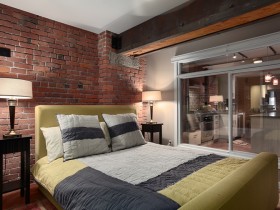 Стильная спальня с кирпичными стенами и яркой кроватью
