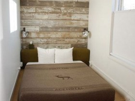 Маленькая белая спальня с деревянной стеной