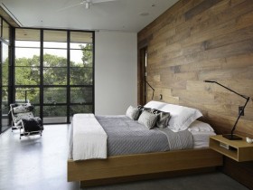 Современная спальня с деревянной стеной