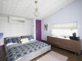 Современная светлая спальня с фиолетовой дверью и скошенным потолком