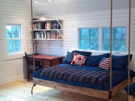 Спальня со скошенным потолком и подвесной кроватью