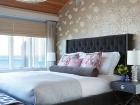 Красивая спальня со скошенным деревянным потолком