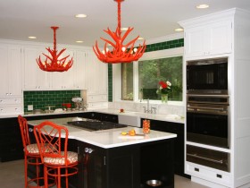 Черно-белая кухня с красными стульями и люстрами