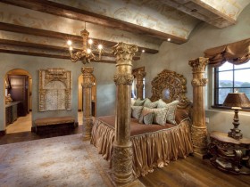 Роскошная спальня в средневековом стиле с колонами и дорогой деревянной мебелью