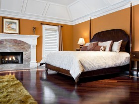 Спальня оранжевого цвета с белым потолком и камином